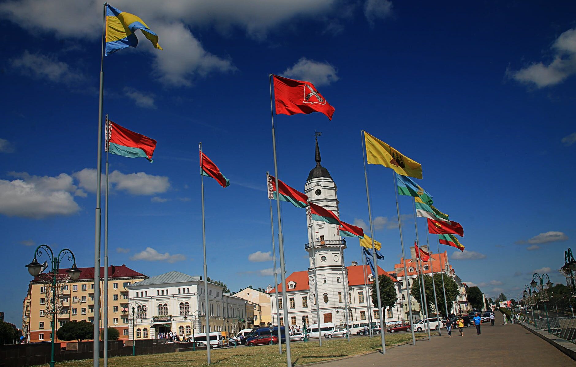 different flags waving on poles at daytime