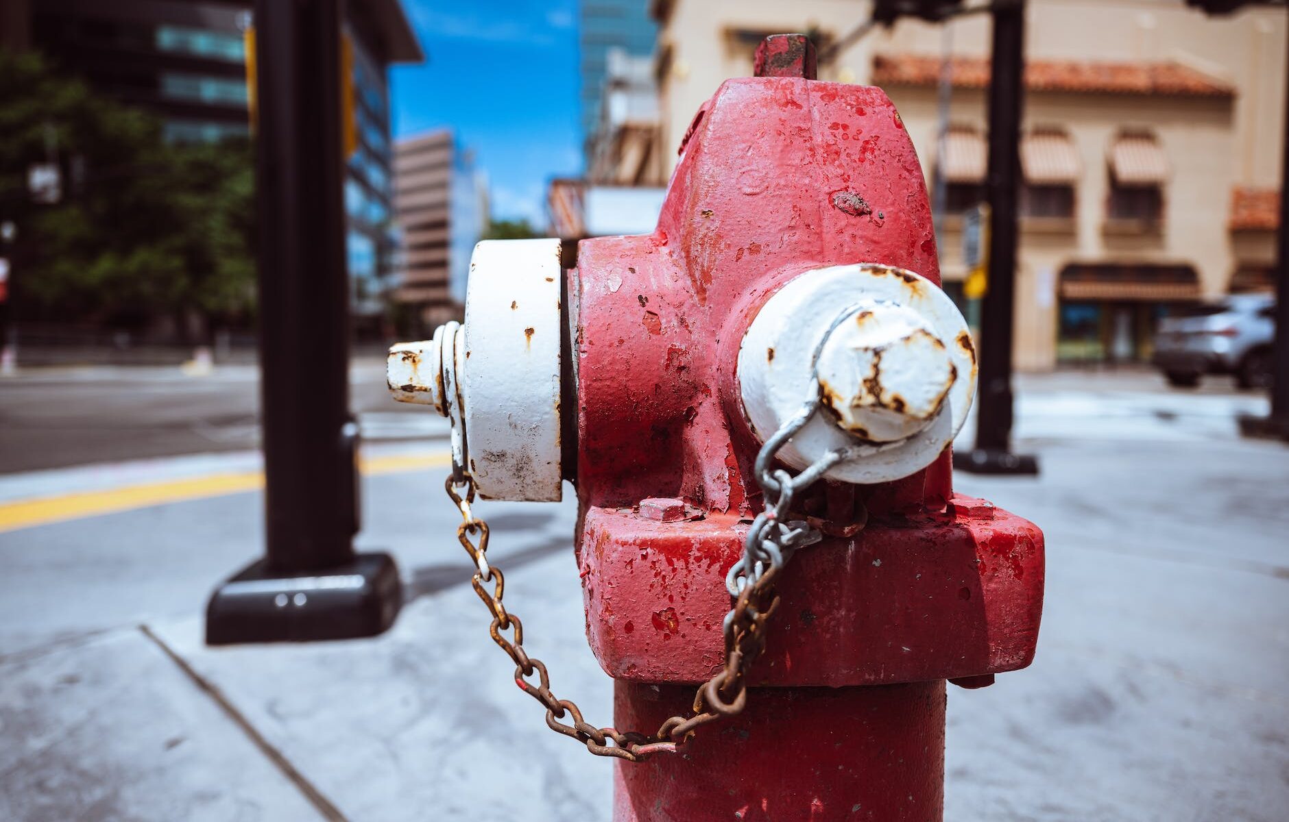 metal fire hydrant on city street against blue sky